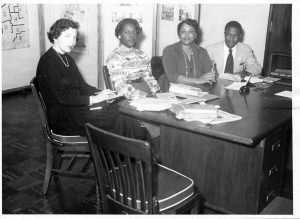 Photographs of four people sitting at a desk